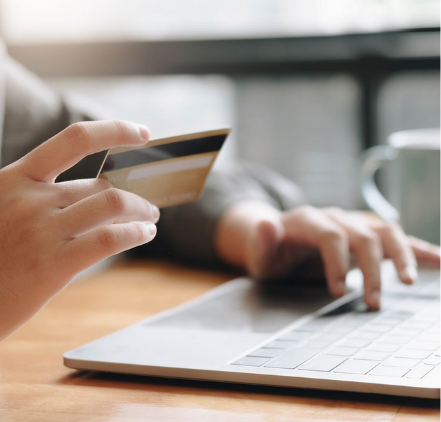 Someone plugging their credit car information into a computer